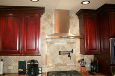 a stove top oven sitting inside of a kitchen next to wooden cabinets and counter tops