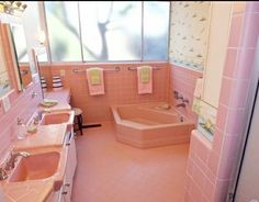 a pink bathroom with two sinks and a bathtub