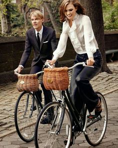 a man and woman riding on the back of a bike