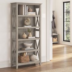 a book shelf with books and vases on it in the corner of a room