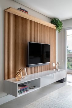 a flat screen tv mounted to the side of a wooden wall in a living room