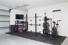 a garage with several different types of exercise equipment in it and a flat screen tv mounted on the wall