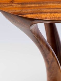 a close up of a wooden table with curves on the top and bottom edge, against a white background