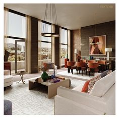 a living room filled with lots of furniture and large windows overlooking the cityscape