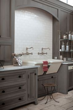 a large kitchen with gray cabinets and white counter tops is pictured in this image from the front view