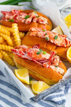 lobster sandwiches and french fries with lemon wedges