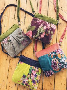 four purses sitting on top of a wooden floor