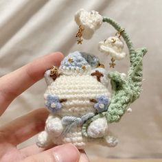 a small crocheted stuffed animal is held in someone's hand with the key chain attached to it