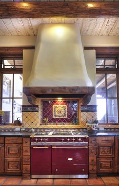 a stove top oven sitting inside of a kitchen next to wooden cabinets and counter tops