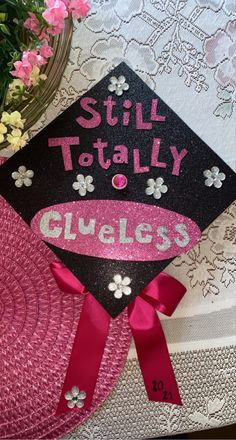 a graduation cap that says still totally gliess on it with flowers in the background