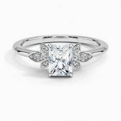 a princess cut diamond ring with pave set diamonds on the shoulders and sides, in 18k white gold