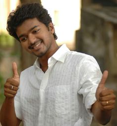 a man giving the thumbs up sign in front of his face and wearing a white shirt