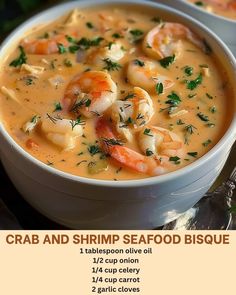 two white bowls filled with seafood soup on top of a table