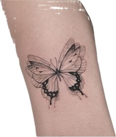 a black and white butterfly tattoo on the arm