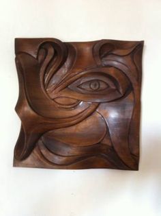 a wooden wall hanging with an eye on it's face and eyes in the center