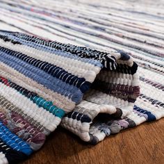 a close up of a multi colored rug on a wooden floor with an area rug underneath it