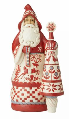 a santa clause figurine holding a christmas tree ornament in his hand