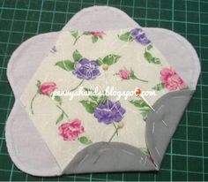 a piece of fabric with flowers on it sitting on top of a green cutting mat