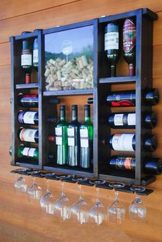 several wine glasses and bottles are lined up on the wall next to an empty glass holder