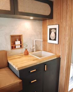 a kitchen with a sink, counter top and wooden cabinetry in the corner next to a bathtub