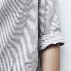 a close up of a person's arm wearing a striped shirt