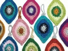 six crocheted potholders are shown in different colors and sizes, each with an ornament shaped like a sunburst