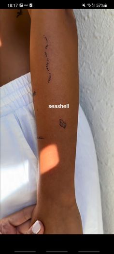 someone is holding their arm with the word seashell written on it in cursive writing