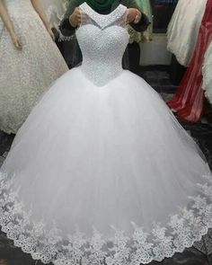 a white ball gown is on display at a wedding dress shop with mannequins in the background