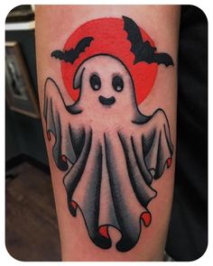 a tattoo with a ghost and bats on it