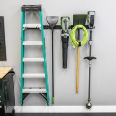 tools are hanging on the wall next to a ladder