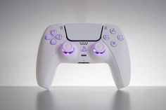 a video game controller sitting on top of a white table next to a gray wall