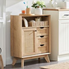 a wooden cabinet with baskets on it in a white and beige room next to a sink