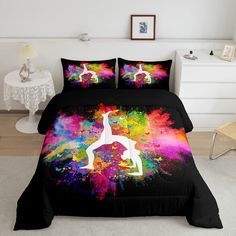 a bed with colorful paint splattered on it and a black comforter cover