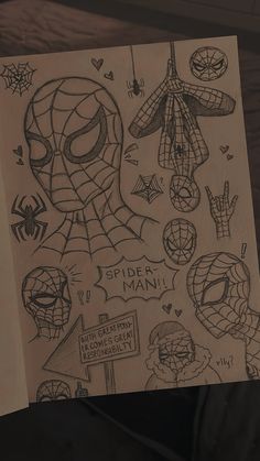 someone holding up a piece of paper with spiderman drawings on it and other things