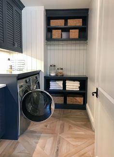 a washer and dryer in a small room with wooden flooring on the walls