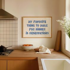 a kitchen with a bowl of fruit on the counter and a framed poster above it