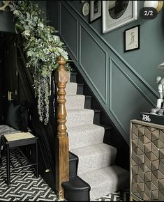 the stairs in this house are decorated with plants and pictures on the wall above them