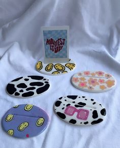 four different shaped magnets sitting on top of a white cloth covered tablecloth next to a greeting card