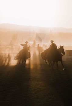 two men on horses chasing each other in the dirt with dust coming from behind them