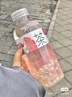 a person holding a bottle of water on the street