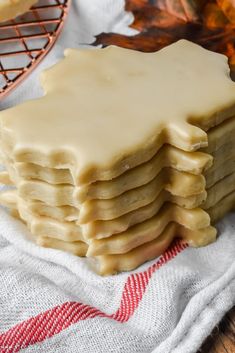 a stack of white frosted cookies sitting on top of a table next to an oven