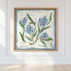 a painting hanging on the wall in a room with wood flooring and white walls