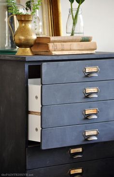 a blue dresser with books and vases on top