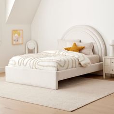 a white bed sitting on top of a wooden floor