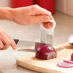 someone using a knife to cut onions on a cutting board