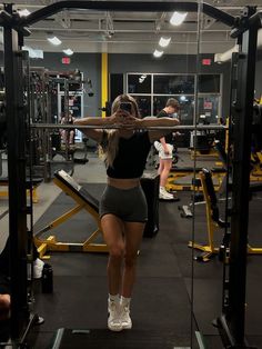 a woman is doing squats in the gym