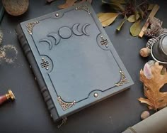 a book sitting on top of a table surrounded by autumn leaves and other things around it