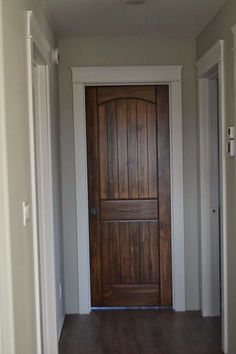 an open door with the words wooden doors on it in front of a hallway leading to another room