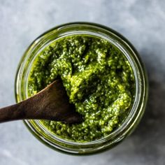 a wooden spoon in a jar filled with pesto