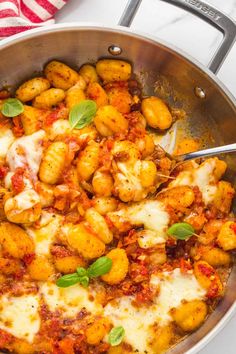 a pan filled with pasta and cheese covered in sauce